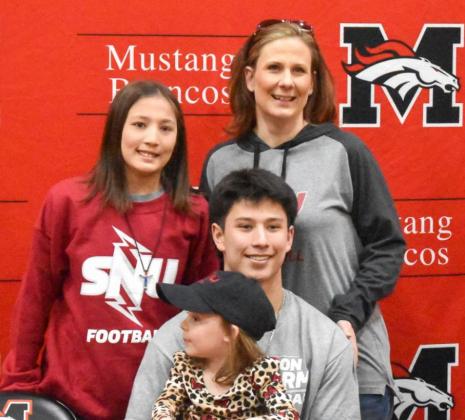 Karston Keene is surrounded by his family Feb. 9 after signing his National Letter of Intent to play football at Southern Nazarene University. Photo / Michael Kinney