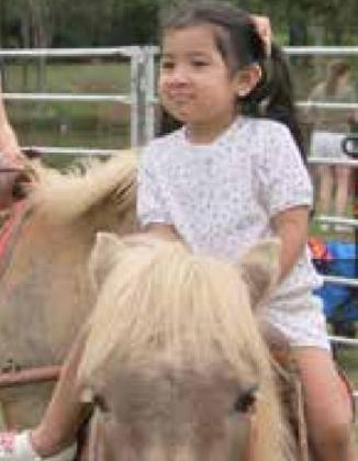 Bella Martinez enjoys her pony ride, thanks to Chester’s Party Barn, during the May 7 Festival of the Child at City Park, 2200 Holly Ave. in Yukon. Photos by Carol Mowdy Bond.