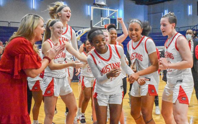 Randi Harding steps up to receive her tournament MVP award as her Mustang teammates cheer her on at the Shawnee Invitational last week. The Lady Broncos won the championship. Photo / Michael Kinney
