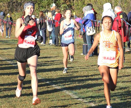 Freshman Londyn Medrano nears the finish line attempting to pass a runner from Tahlequah at the state meet at Edmond Santa Fe Oct. 30. Mustang finished 12th in the state at the event. Photo / Michael Pineda