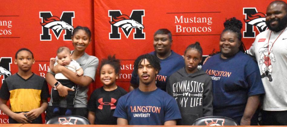 Cameron Broadus is surrounded by family as he signs his letter of intent to play football at Langston University. Photo / Michael Kinney