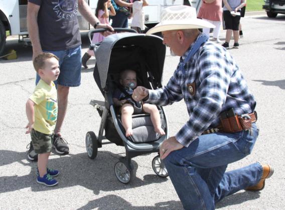 Canadian County Sheriff Chris West visits with Logan and Rowan Brooks during Friday Fun Day. Photo / Michael Pineda
