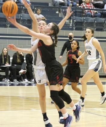 Yukon guard Caid Jefferson gets a shot off just beyond the outstretched hands of an Edmond North defender. The Millerettes fell in the regional title game but advancd to area. Photo / Michael Pineda