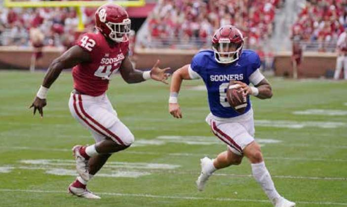 Oklahoma quarterback Dillon Gabriel (8) carries past Noah Arinze (42) during the school’s NCAA college spring football game, Saturday, April 23, 2022, in Norman, Okla. Photo by Sue Ogrocki.