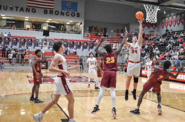 Mustang’s Jacob Henderson cleared out space for himself as he went up for a basket against Putnam City North Dec. 29, 2021. It was the Broncos’ first time winning the Cornerstone Holiday Classic. Photo / Michael Kinney